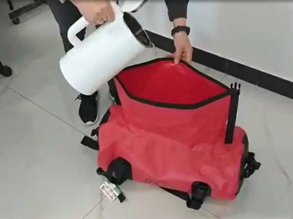 Pouring water to a waterproof duffel bag for testing